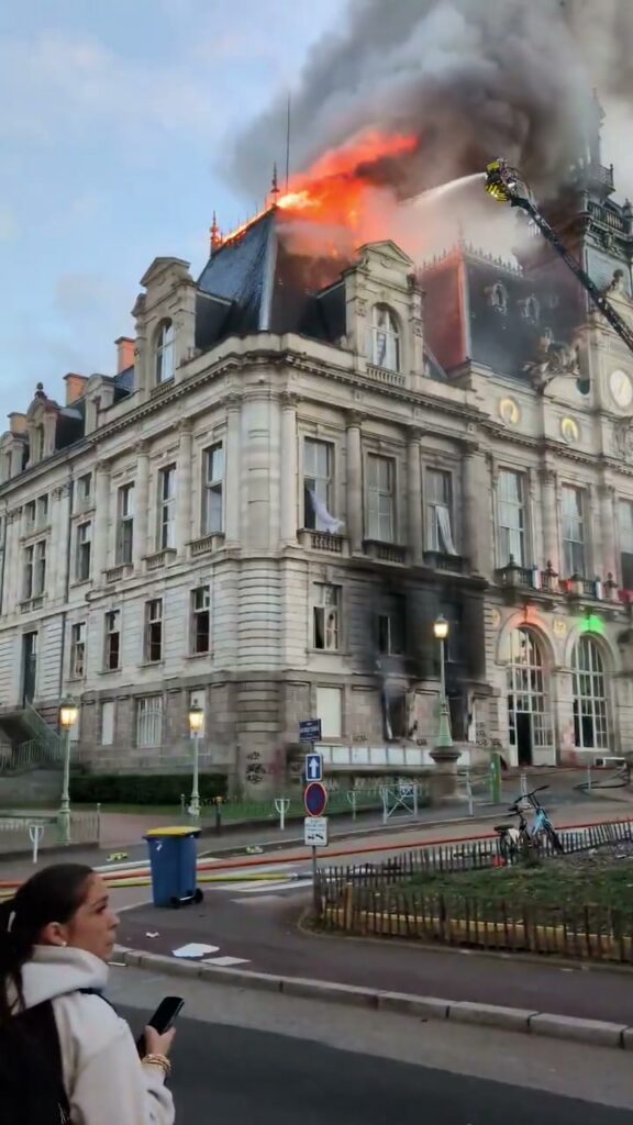 Limoges city hall roof on fire, firefighters on a ladder